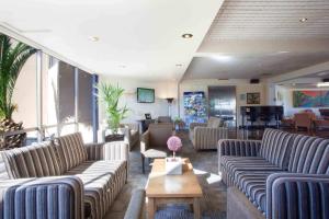 a waiting room with couches and a table at Auckland Airport Kiwi Hotel in Auckland