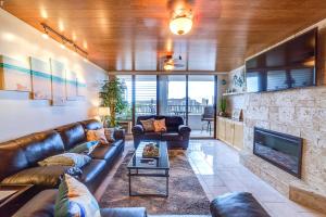 a living room with a leather couch and a fireplace at Central Waikiki Luxury Penthouse in Honolulu