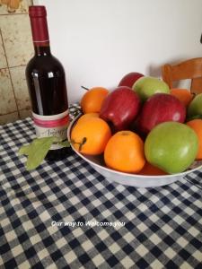ネア・マクリにあるNicolas Dreamのワイン1本とテーブルの上にフルーツを盛り付けたボウル