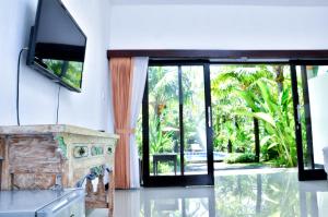 a living room with a fireplace and a tv at Palm Garden Bali in Nusa Dua