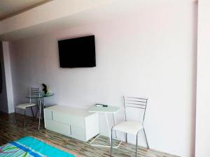 a room with two chairs and a table and a tv on a wall at Jomtien beach Condominium S2 in Jomtien Beach