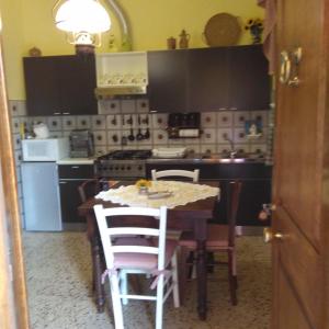 a kitchen with a table with chairs and a stove at Bargoncello in Riccò del Golfo di Spezia