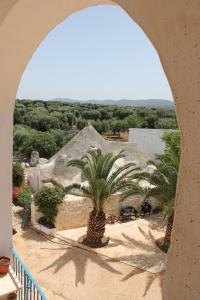 an archway with two palm trees and a building at Masseria Gianecchia in Cisternino