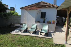 three chairs sitting on a patio in front of a house at Casas da Nazare in Ponte de Lima