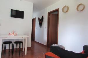 a living room with a table and chairs and a television at Casas da Nazare in Ponte de Lima