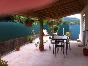 a patio with a table and chairs under a pergola at Casas da Nazare in Ponte de Lima +7 photos