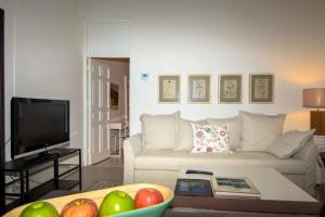 - un salon avec un canapé blanc et une télévision dans l'établissement Apartamento Piamonte, à Madrid