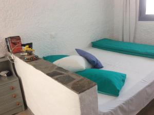 a bedroom with a white bed with green pillows at Rosys Little Village in Skala