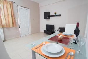a table with a plate and wine glasses on it at Naiades Luxury Apartments in Kalathas