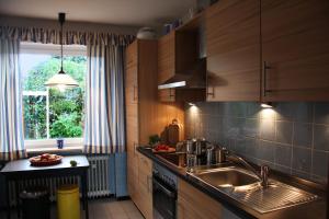オッテルンドルフにあるVilla Ludwig Fewoのキッチン(木製キャビネット、シンク、窓付)