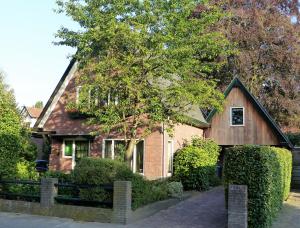 a brown house with a black roof at B&B Onder de rode beuk in Dieren