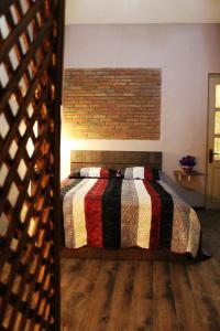 1 dormitorio con cama y pared de ladrillo en Old castle Apartment, en Tiflis