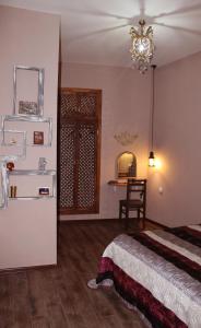 1 dormitorio con cama, mesa y lámpara de araña en Old castle Apartment, en Tiflis