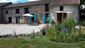 a stone house with a garden in front of it at 17 St Romain in Saulgond