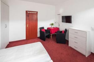 Zimmer mit einem Tisch, Stühlen und einem roten Teppich in der Unterkunft Gästehaus Bakker in Norderney