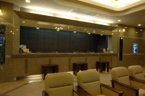 a waiting room with chairs and a large stage at Hotel Route-Inn Kushiro Ekimae in Kushiro