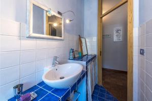 スポトルノにあるGolfo dell'Isola Appartamentoのバスルーム(白い洗面台、鏡付)