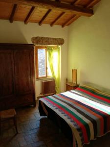 a bedroom with a bed with a colorful striped blanket at Casamatta a Blera in Blera