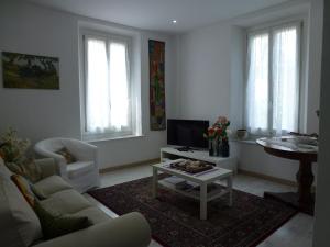 sala de estar con sofá, TV y mesa en Casa Giardino, en Gravedona