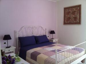 1 dormitorio con cama blanca y pared morada en Casa Giardino, en Gravedona