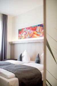 ein Schlafzimmer mit 2 Betten und einem Wandgemälde in der Unterkunft Hotel Cloppenburg in Cloppenburg