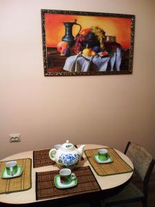 SalavatにあるМини-гостиница УЮТの花瓶とカップ2杯付きテーブル
