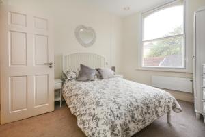 una camera bianca con un letto e una finestra di Minster's Keep- Stylish Apartment Near York Minster a York