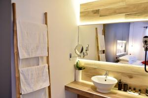 uma casa de banho com um lavatório e um espelho em Piteoussa em Hidra