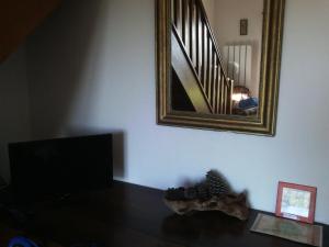 ein Wohnzimmer mit einem Spiegel und einem Tisch mit Schuhen in der Unterkunft Chambres d'hôtes La Fouquette in Les Mayons