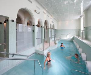 a group of people in a swimming pool at Maison d'Hôtes l'Escale in Bains-les-Bains