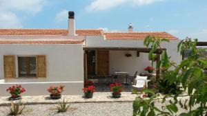 a white house with flowers in front of it at Monte Atena B&B di Charme in Stintino