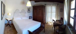 a bedroom with a bed and a desk and a window at Monte Atena B&B di Charme in Stintino