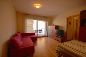 uma sala de estar com um sofá vermelho e uma televisão em Lets Holidays Apartment Vinya del Pla em Tossa de Mar