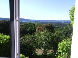 ein Fenster mit Blick auf ein Feld von Bäumen in der Unterkunft Chambres d'hôtes La Fouquette in Les Mayons