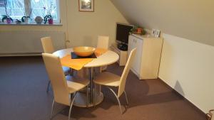 eine Küche mit einem Tisch und Stühlen sowie einem Kühlschrank in der Unterkunft Ferienwohnungen An der Ostsee in Wittenbeck