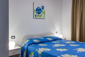 a bedroom with a bed with a blue comforter at B&B La Piazzetta in Licata