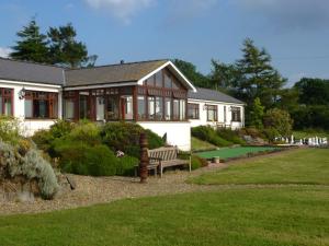 uma casa com um banco em frente a um quintal em Ael y Bryn Luxury B&B, North Pembrokeshire em Eglwyswrw