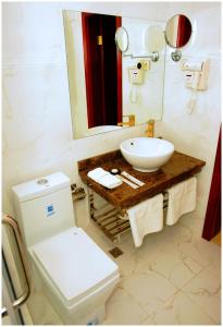 a bathroom with a white toilet and a sink at Goldman Empire in Astana