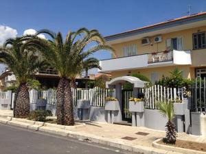 a house with palm trees in front of a fence at Villa Due Palme in Avola