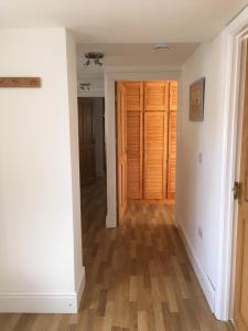 a hallway with white walls and a wooden door at Maesbury Riverside in Oswestry