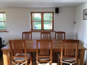 a dining room with a wooden table and chairs at Maesbury Riverside in Oswestry