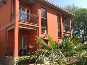 una casa rossa con una palma di fronte di Appartamento Sophia a Collegno
