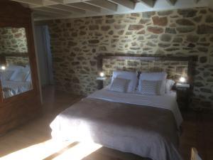 a bedroom with a bed and a stone wall at La Chambre Montbrault in Fleurigné