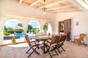 a dining room with a wooden table and chairs at Casa Garonda in Cala Pi