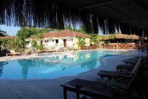 a swimming pool with chairs and a waterfall at Hotel Riverside in Dalyan