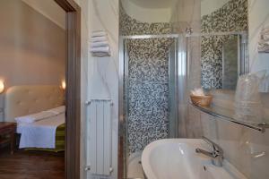 ein Bad mit einem Waschbecken und einer Dusche mit einer Badewanne in der Unterkunft Hotel Universo in Turin