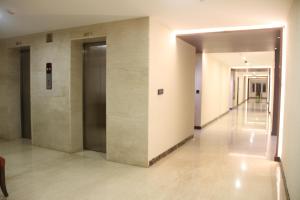 un pasillo de un edificio de oficinas con dos ascensores en Lakshmi Hotel, en Thanjāvūr
