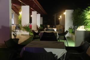 un restaurante con mesas, sillas y plantas en Lakshmi Hotel, en Thanjāvūr