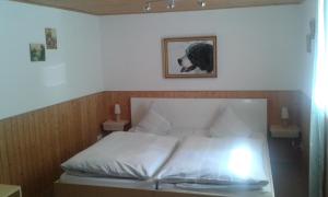 a bedroom with a white bed with a picture on the wall at Mühlbachhof in Berg
