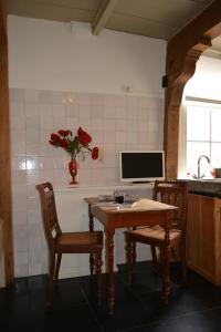 Il comprend une cuisine avec une table et deux chaises ainsi qu'une télévision. dans l'établissement Waterland Achterhuis, à Monnickendam